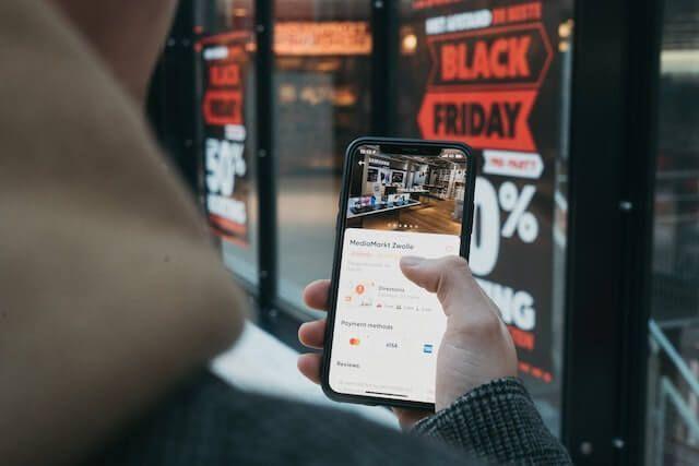 man using phone to check black friday deals